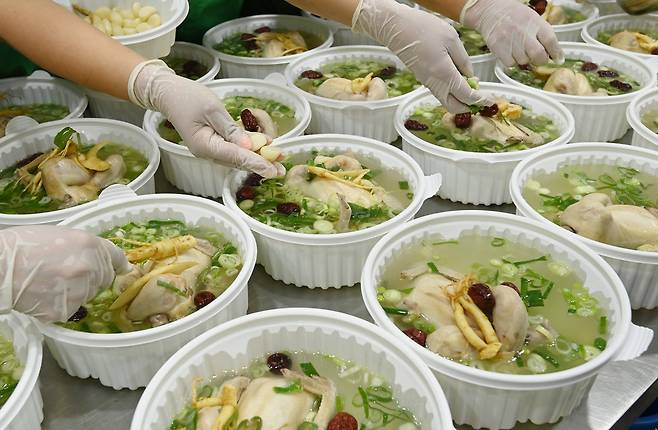 복날을 앞두고 삼계탕을 포장 용기에 담는 관계자들. 최근 영계, 찹쌀, 마늘 등 주요 재료 가격이 상승하면서 직접 끓이는 비용도 부담이 커지고 있다. 뉴시스