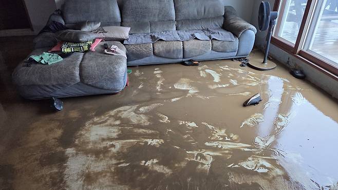 17일 오전 충남 서산에 많게는 400㎜ 넘는 물 폭탄이 쏟아진 가운데 음암면 유계리를 지나는 도당천이 범람하면서 물에 잠겼던 한 주택 거실이 난장판으로 변해 있다. 서산=연합뉴스
