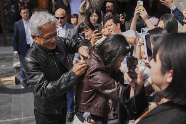 젠슨황 엔비디아 최고경영자(CEO)가 16일 베이징에서 열린 제3회 중국 국제공급망촉진박람회에 참석한 후 만다린 오리엔탈 첸먼에서 기자회견 도중 한 기자의 가죽 재킷에 사인을 하고 있다. AP연합