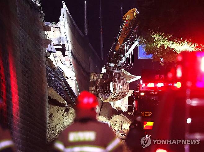 오산 옹벽붕괴 현장 (오산=연합뉴스) 권준우 기자 = 16일 오후 경기 오산시 가장동 가장교차로 고가도로의 10ｍ 높이 옹벽이 도로로 무너지며 고가도로 아래 도로를 지나가던 차량을 덮치는 사고가 났다. 
사진은 사고 현장에서 흙더미를 파내는 굴착기의 모습. 2025.7.16 stop@yna.co.kr