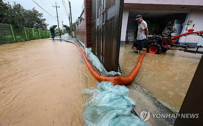 마당까지 차오른 빗물 (청도=연합뉴스) 윤관식 기자 = 청도에 호우경보와 산사태경보가 발령된 17일 경북 청도군 청도읍 구미리 한 마을에서 산사태가 발생한 가운데 한 주민이 마당까지 차오른 빗물을 빼내고 있다. 2025.7.17 psik@yna.co.kr