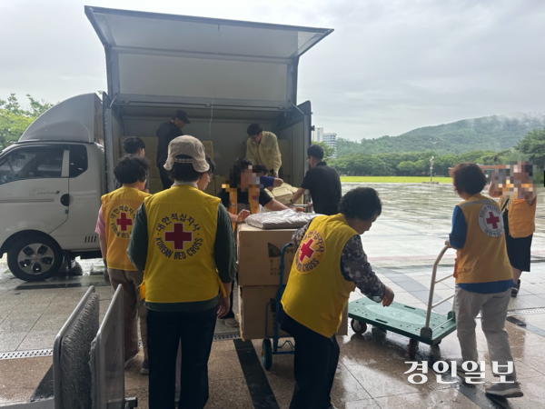 18일 오전 광명시 시민체육회관에 마련된 대피소에서 대한적십자사 소속 자원봉사자들이 아파트 화재로 집이 소실된 이재민들을 위한 구호물품을 옮기고 있다. 2025.7.18 /목은수기자wood@kyeongin.com