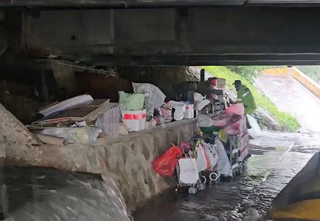 지난 17일 폭우에 박상현 경감이 문창교 교량 밑 노숙인들의 대피를 지원 중인 모습 (사진=대전경찰청 제공)