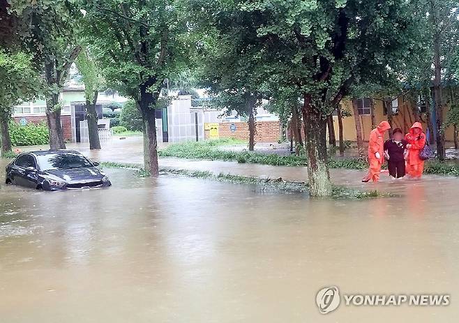 호우특보가 발효된 17일 오후 전남 담양군 고서중학교 인근 도로가 물에 잠겨 소방 당국이 안전 조치를 하고 있다. 연합뉴스