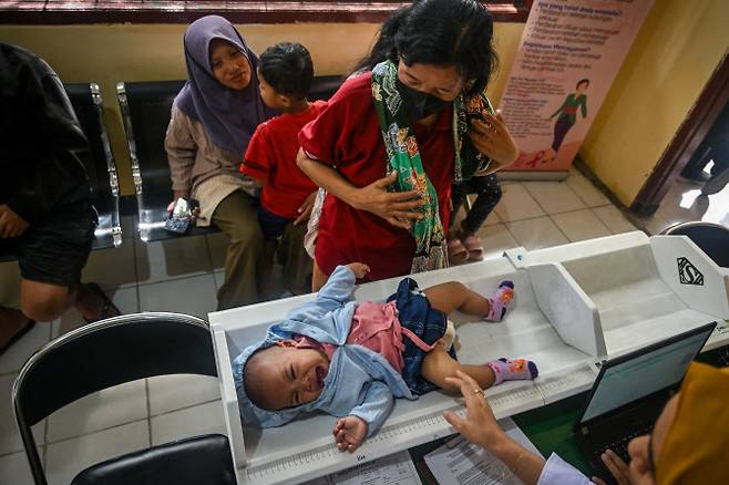 지난 2월 인도네시아 수라바야에서 열린 전국 무료 건강검진(PKG) 프로그램 개막일에 의료진이 지역 보건소에서 아기를 살펴보고 있다. (사진=AFP)