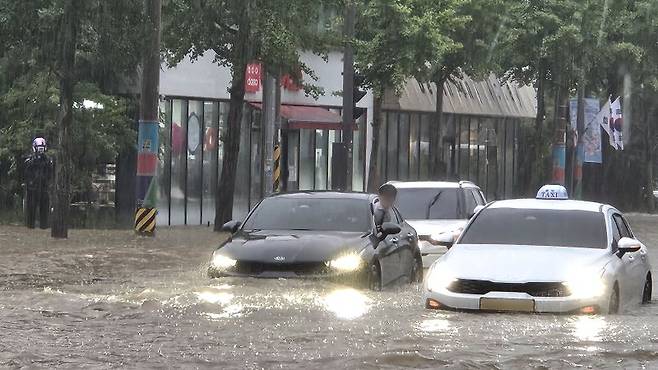 광주지역에 시간당 86㎜ 폭우가 쏟아진 17일 오후 광주 북구청 앞 교차로에서 차량들이 폭우로 넘치는 빗물에 갇혀 오가지 못하고 있다. 뉴시스