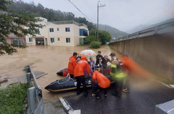 지난 17일 집중호우가 쏟아진 경남 밀양시 무안면 한 노인요양원에서 밀양소방서 구조대원들이 환자와 직원들을 구조하고 있다. 사진 경남소방본부