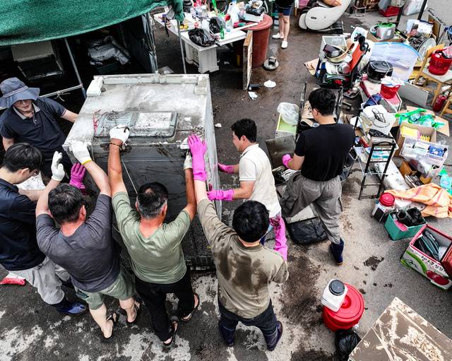 ▲ 18일 전날 내린 폭우로 침수 피해를 본 대구 북구 노곡동 한 가정집에서 주민과 공무원들이 복구 작업을 하고 있다. 2025.7.18 연합뉴스