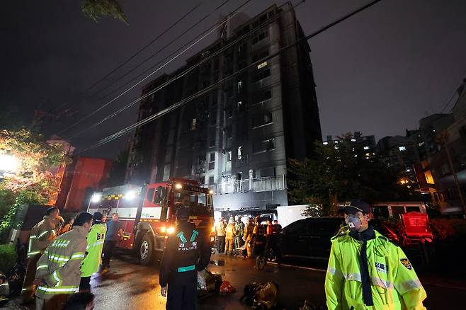 18일 소방대원이 전날 주차장에 불이 난 경기도 광명시 소하동 한 아파트에서 인명 수색하는 가운데 경찰이 현장을 통제하고 있다. 연합뉴스