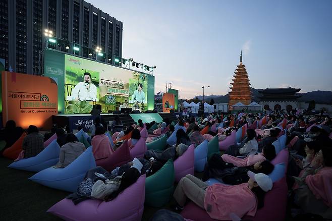 Author Park Sang-young speaks to a full crowd at the Seoul Outdoor Library’s Hip Dok Club event in Gwanghwamun Square. He shared behind-the-scenes stories from writing "Love in the Big City" and reflected on adapting his work for film and television. (Seoul Metropolitan Government)