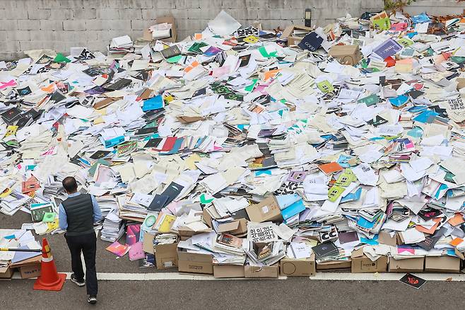 Stacks of discarded test prep books fill the parking lot of a cram school in Seoul on November 14, 2024, the day of the 2025 College Scholastic Ability Test. In Korea, countless books used solely for the college entrance exam are routinely thrown away once the test is over. [NEWS1]