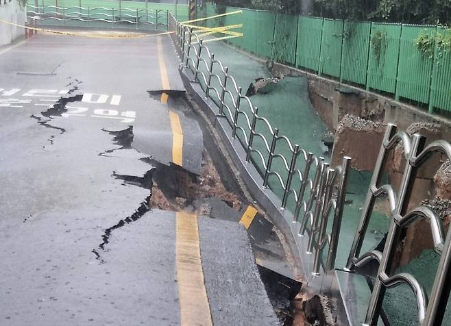 시간당 80㎜의 극한 호우가 쏟아진 17일 오후 2시 20분쯤 광주 계림동 광주고등학교 인근 인도와 도로가 갈라졌다는 신고가 접수됐다. 사진은 통제된 현장 모습/사진=뉴스1, 광주 동구 제공
