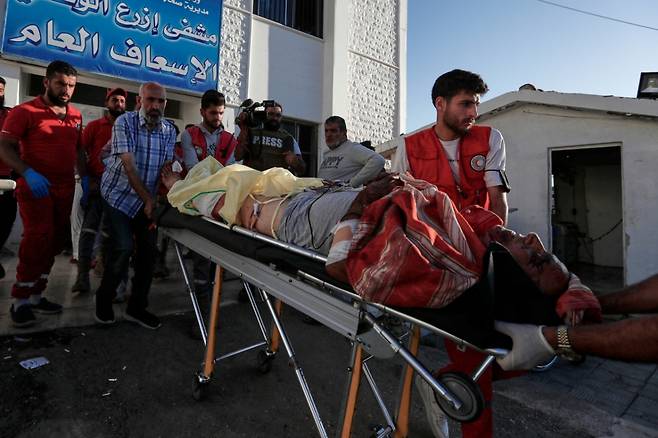 14일(현지 시간) 시리아 남부 스웨이다 외곽에서 드루즈족 민병대와 수니파 베두인 부족 간 무력 충돌이 벌어진 가운데, 시리아 적신월사 자원봉사자들이 부상자를 들것에 실어 에즈라 병원으로 옮기고 있다. /AP=뉴시스