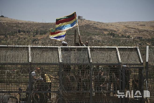 [마즈달샴스=AP/뉴시스] 7월16일 시리아-이스라엘 접경 지역에서 드루즈 부족이 시위를 벌이는 모습이 이스라엘이 지배하는 골란고원 마즈달샴스에서 관측되고 있다. 시리아 남부 수와다에서는 시리아 정부군과 드루즈족 무장 세력 간 충돌이 이어졌다. 2025.07.18.