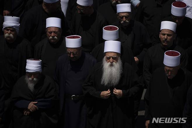 [골란고원=AP/뉴시스] 2024년 7월28일 이스라엘이 점령한 골란고원에서 드루즈 성직자들이 전날 마즈달 샴스 마을 축구장에 떨어진 로켓포탄에 숨진 어린이와 청소년의 장례식에 참석하고 있다.  2025.07.18.