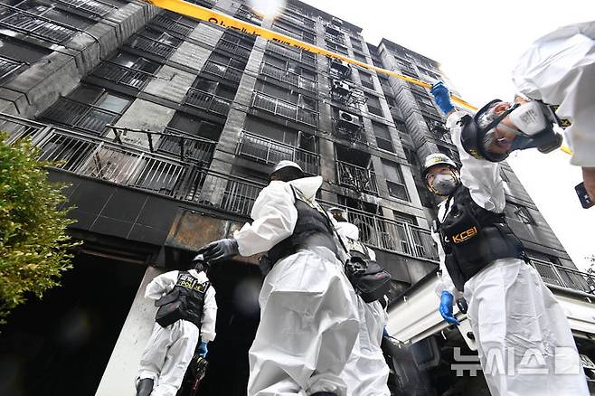 [광명=뉴시스] 김종택 기자 = 경찰과 소방 및 국립과학수사연구원 등 관계자들이 18일 경기 광명시 아파트에서 합동감식을 위해 화재현장으로 이동하고 있다. 앞서 지난 17일 오후 9시5분께 이 아파트 주차장 필로티 천장에서 불이나 1명이 숨지고 64명이 부상을 입었다. 2025.07.18. jtk@newsis.com