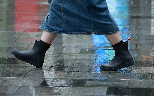 한 시민이 장화를 신고 서울 청계천 일대를 지나고 있다. 뉴시스