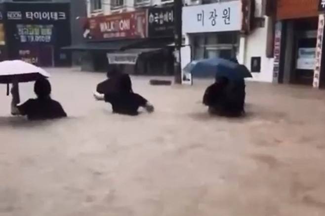 흙탕물에 잠긴 광주 - 광주 전역에 폭우가 쏟아진 17일 북구 용봉동 거리에서 시민과 학생들이 가슴 높이까지 차오른 흙탕물을 헤치며 귀가하고 있다.  광주 연합뉴스