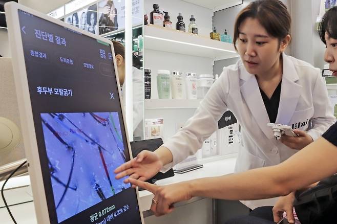 신세계백화점이 운영하는 뷰티 편집숍 ‘시코르’ 강남역점에서 고객이 인공지능(AI) 두피 진단을 받고 있다. 시코르 강남역점은 플래그십 매장으로 지난달 문을 열었다. 신세계 제공
