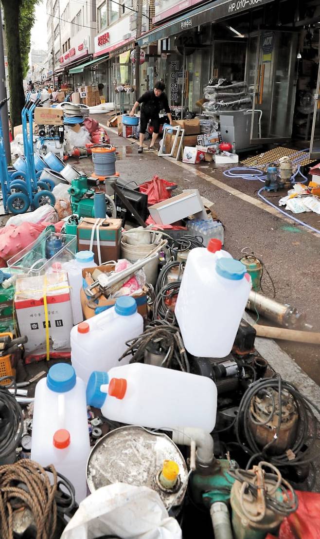 광주 공구거리도 침수 피해 - 지난 17일 쏟아진 폭우로 광주광역시 북구 '공구의 거리'도 침수 피해를 입었다. 18일 오전 가게마다 빗물을 뒤집어쓴 물통, 장비 등을 꺼내 씻고 있다. /김영근 기자