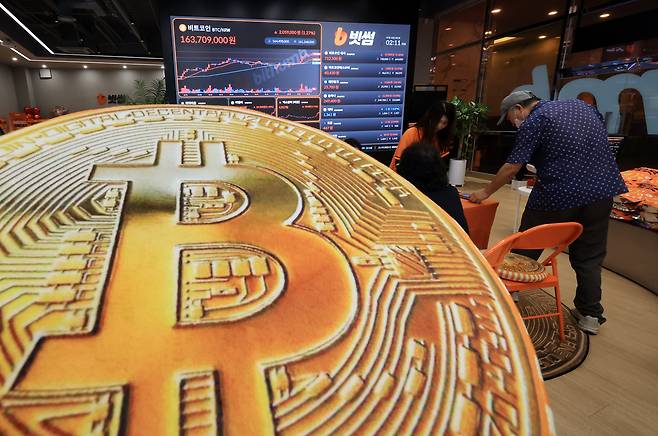 지난 18일 오후 서울 강남구 서초구 빗썸라운지 강남본점에서 비트코인 모형이 놓인 바닥에 코인 시세 그래프가 비치는 모습. /뉴스1