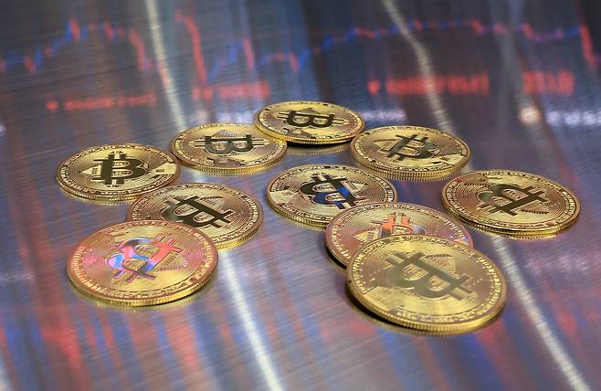 지난 18일 오후 서울 강남구 서초구 빗썸라운지 강남본점에서 비트코인 모형이 놓인 바닥에 코인 시세 그래프가 비치는 모습. /뉴스1