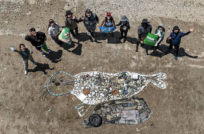 클린하이커스 회원들이 지난 12일 인천광역시 옹진군 영흥면 선재도 해안에서 주운 쓰레기로 바위 위에 앉은 서해 점박이물범 정크아트를 만들었다. 김성룡 기자