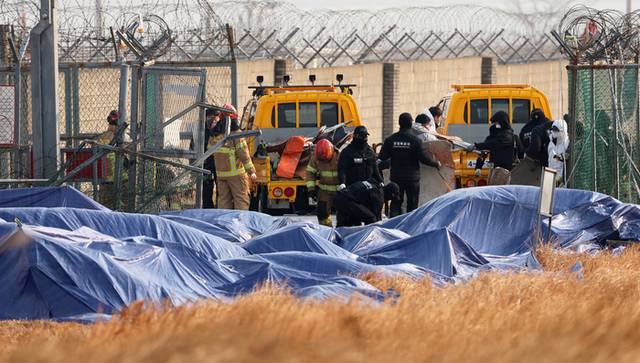 ▲ 제주항공 여객기 참사 9일째인 지난 6일 오전 전남 무안공항에서 경찰특공대원과 소방대원들이 울타리 밖에 있던 기체 잔해를 옮기고 있다. 연합뉴스