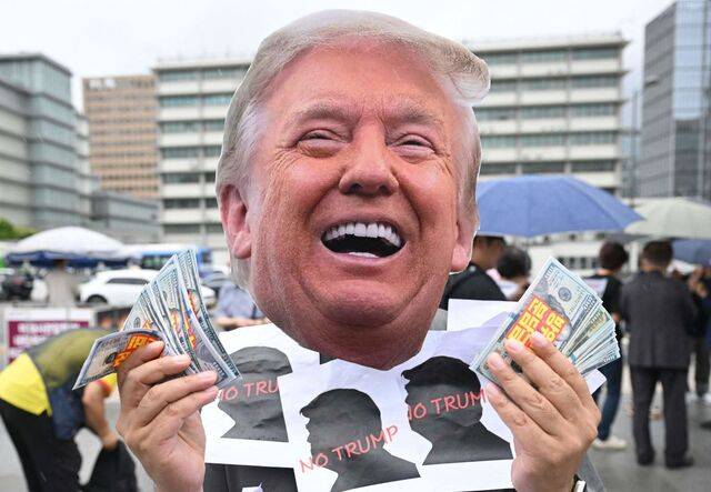 시민단체 활동가가 지난 15일 서울 종로구 주한 미국대사관 앞에서 도널드 트럼프 대통령 가면을 쓰고 트럼프의 경제·안보 수탈에 반대하는 퍼포먼스를 벌이고 있다. AFP연합뉴스