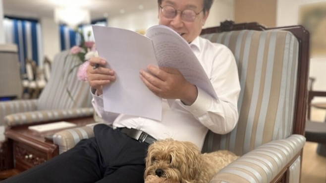 이재명 대통령이 서울 한남동 관저에서 반려견 바비와 함께 앉아 서류를 읽고 있는 모습. [사진출처= 이재명 대통령 인스타그램 갈무리]