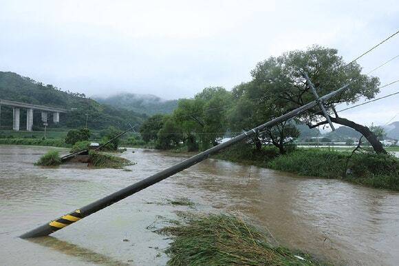18일 충남 공주시 사곡면에서 한 도로가 무너져 내렸고 전봇대가 위태롭게 쓰러져 있다. 연합뉴스