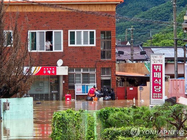 침수로 고립된 마을 주민 구조하는 소방대원들 (서울=연합뉴스) 19일 오후 경남 의령군 대의면 집중호우로 인해 마을이 침수돼 출동한 소방대원들이 보트를 이용해 건물에 고립된 마을 주민을 구조하고 있다. 2025.7.19 
    [소방청 제공. 재판매 및 DB 금지] hkmpooh@yna.co.kr