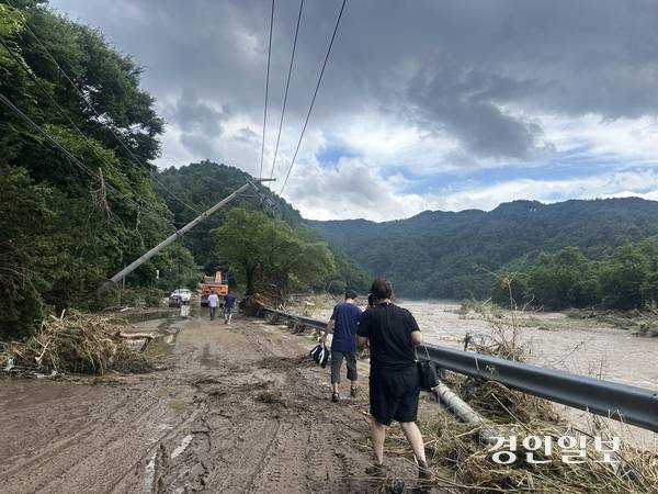 20일 오후 새벽시간대 내린 집중호우로 인해 가평군 조종면 일대 강변 도로는 전신구가 무너지고 진흙에 뒤덮였다. 이날 대보2리 등 지역에 통신이 끊기면서 일부 주민들은 가족들의 생사를 확인하기 진흙으로 뒤덮인 도로를 걸어서 들어갔다. 2025.7.20 /목은수기자wood@kyeongin.com
