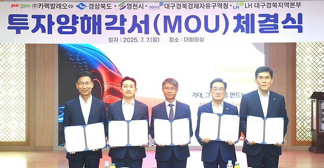 지난 7일 경북 영천시청에서 열린 <주>카펙발레오의 영천하이테크파크지구 투자양해각서 체결식에서 관계자들이 협약서를 들어보이고 있다. <DGFEZ 제공>