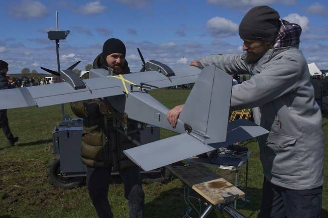 지난 4월 우크라이나에서 열린 국방전시회에서 한 기술자들이 정찰용 무인기(드론)을 조립하고 있다. AP연합뉴스