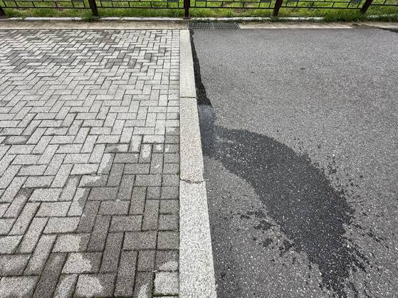 서울시 송파구 풍납동의 한 이면도로에 설치된 투수블록(왼쪽)과 아스팔트에 같은 양의 물을 부었다. 투수불록은 1m 이내에서 물이 흡수된 반면, 아스팔트에서는 물이 빗물받이까지 흘러갔다. 천권필 기자