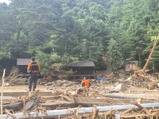 20일 매몰 사고가 발생한 경기도 가평군 조종면 캠핑장 입구에 토사와 강물에 휩쓸려 무너진 건물 잔해와 나무 더미가 쌓여있다. 진입로 겸 다리가 계곡물에 휩쓸려 떠내려가 포클레인 등 장비가 진입하지 못해 소방당국이 구조에 어려움을 겪고 있다. 가평=전율 기자