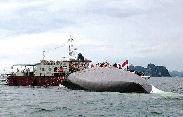 베트남 구조대원과 국경경비대원들이 20일(현지시간) 꽝닌성 하롱베이 인근 해역에 뒤집힌 채 선체 일부를 수면 위로 드러낸 유람선 주변에서 실종자를 수색하고 있다. 신화연합뉴스