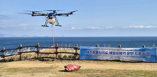 [제주=뉴시스] 제주도는 10일 '드론특별자유화구역 조성사업 완료보고회'를 열고 서귀포시 마라도 절벽 인근의 쓰레기를 드론으로 수거하는 장면을 실시간으로 중계했다. (사진=제주도 제공) 2024.12.11. photo@newsis.com *재판매 및 DB 금지