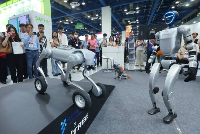 지난달 서울 강남구 코엑스에서 열린 제14회 스마트테크코리아에서 휴머노이드 로봇과 로봇 개가 동작 시연을 하고 있다. 연합뉴스
