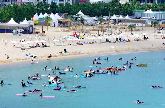 피서철이 절정이던 지난해 7월29일, 강원도 양양군 인구해변에서 피서객들이 서핑을 즐기고 있다.ⓒ연합뉴스