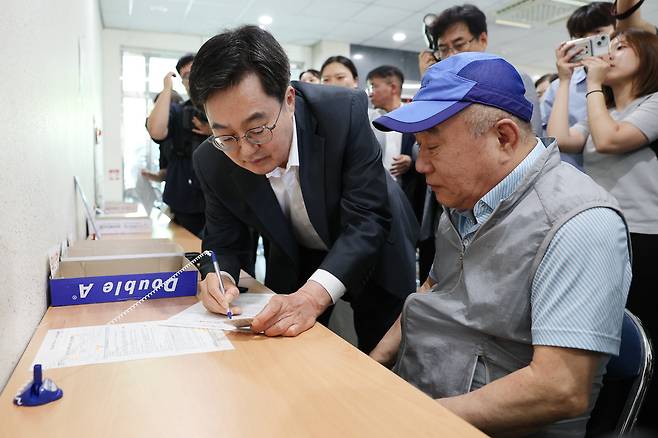 21일 수원 원천동 행정복지센터에서 민원인의 민생회복 소비쿠폰 신청을 돕는 김동연 경기지사 <경기도 제공>