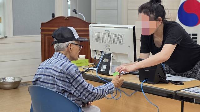 ▲ 21일 충북 청주시 봉명1동 행정복지센터에서 한 시민이 민생회복 소비쿠폰을 신청한 뒤 청주페이를 발급받고 있다. /남연우 기자