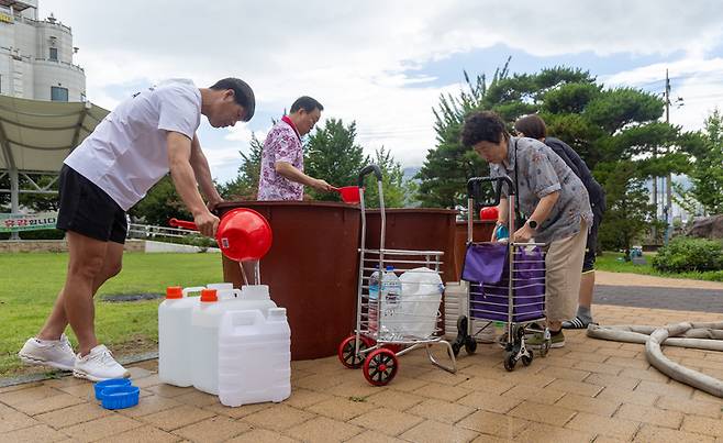 집중호우로 인한 상수도관 파손으로 단수 피해가 이어지고 있는 21일 울주군 언양읍 행정복지센터에서 시민들이 물통에 물을 채우고 있다. 최지원 기자