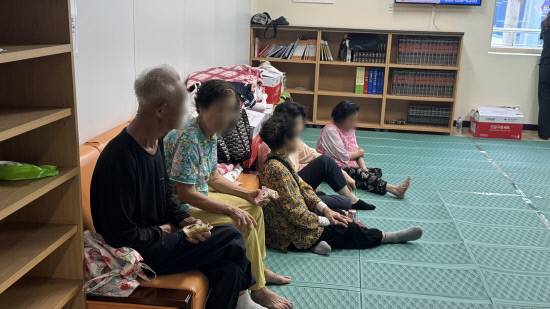 21일 집중 호우로 마련된 대피소 '산엔청복지관'에 대피 주민들이 수심 가득한 표정으로 휴식을 취하고 있다. 정웅교기자