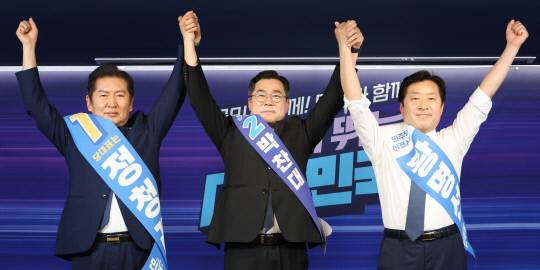 정청래·박찬대(가운데) 더불어민주당 당대표 후보, 황명선 최고위원 후보(오른쪽)가 20일 서울 여의도 당사에서 열린 8·2 전당대회 순회 경선 영남권 합동연설회에서 손을 맞잡고 인사하고 있다. 연합뉴스