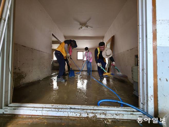 기록적인 폭우에 침수피해를 입은 광주 북구 신안교 주변 주택에서 광주지역 사회봉사단체들이 무더위에 땀을 흘리며 복구 작업 자원 봉사활동을 하고 있다. 박영철 기자 skyblue@donga.com