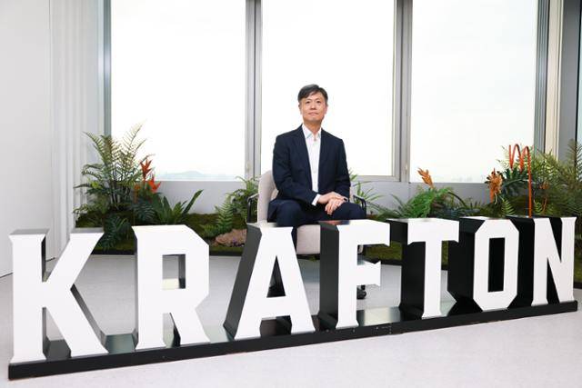 장병규 크래프톤 의장이 크래프톤 기업 로고를 앞에 두고 포즈를 취하고 있다. 크래프톤 제공