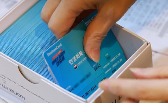 민생회복 소비쿠폰 신청이 시작된 21일 서울 동작구 대방동주민센터에서 직원이 소비쿠폰 신청을 접수하고 있다. [사진=연합뉴스]