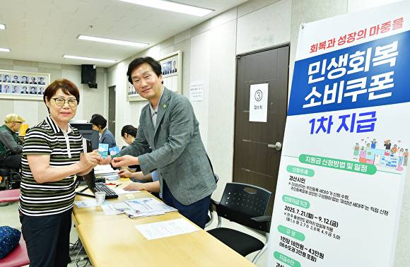 조현일 경산시장이 시민과 소비쿠폰을 들어보이고 있다 [사진=경산시]